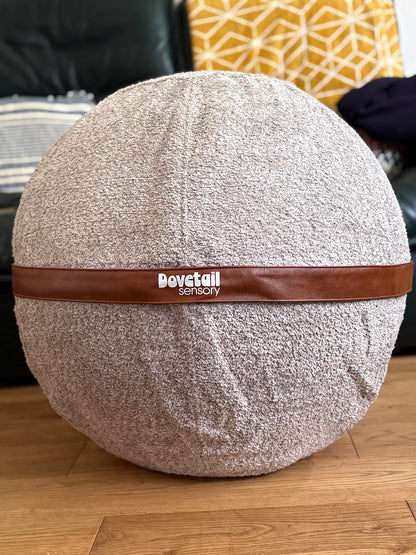Round textured  ball with a brown band and 'Dovetail sensory' branding on a wooden floor.