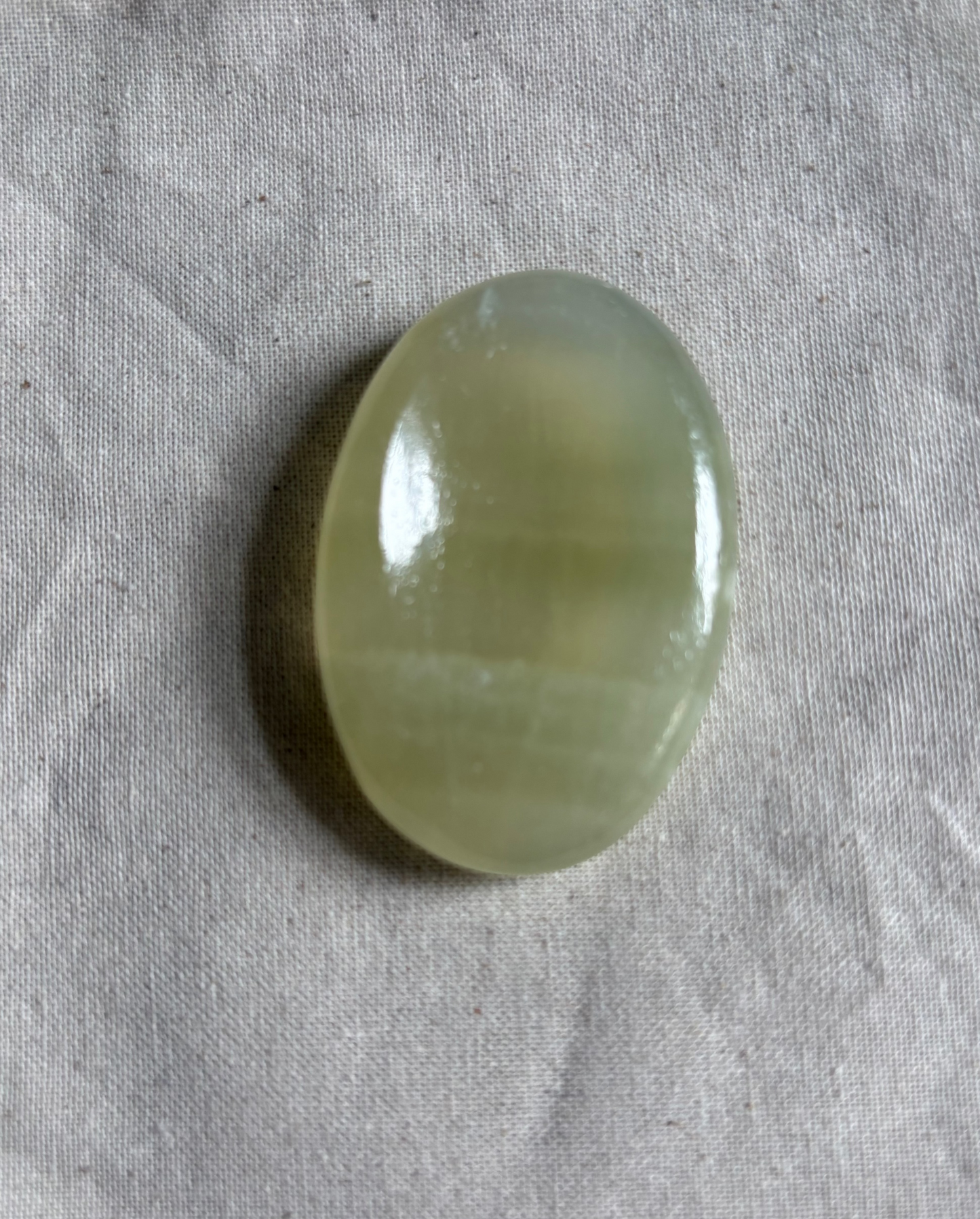 Green stone on a textured gray fabric background
