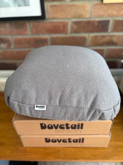 Gray cushion on a Dovetail Sensory box against a brick wall.