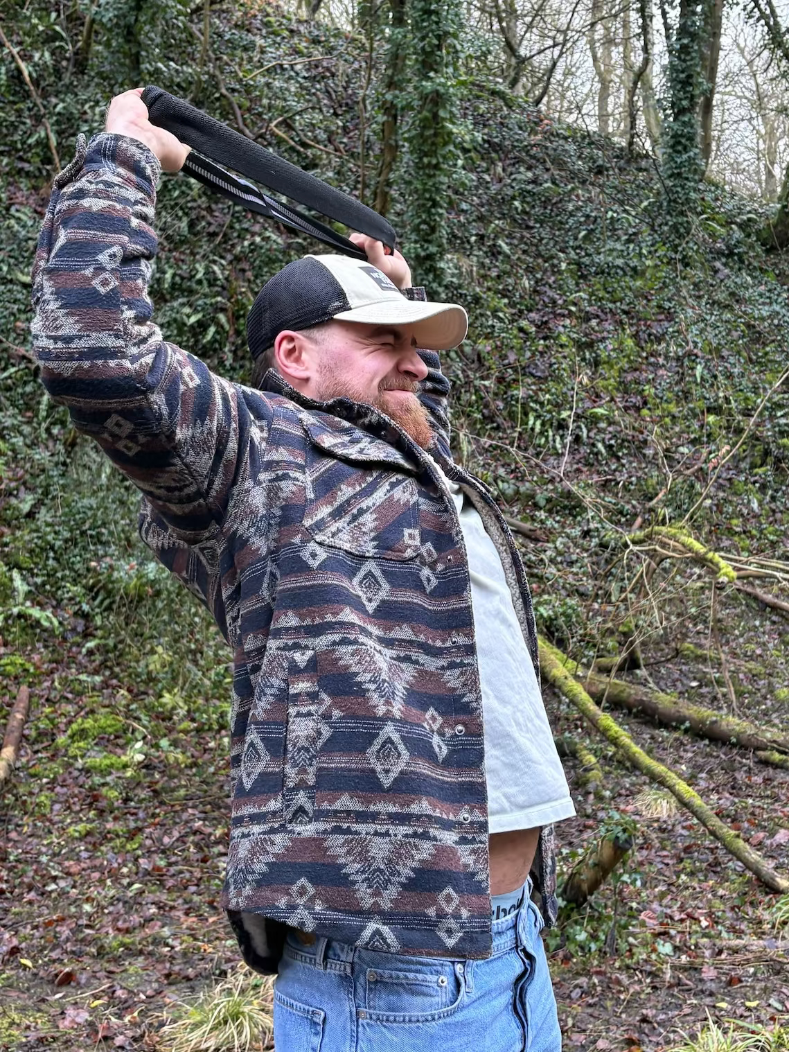Man stretching a resistance band in the woods